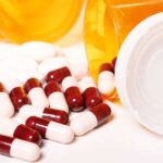 A drug rehab center's medicine bottle with pills and drug addiction treatment on a white surface.