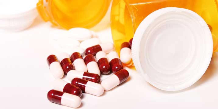 A drug rehab center's medicine bottle with pills and drug addiction treatment on a white surface.