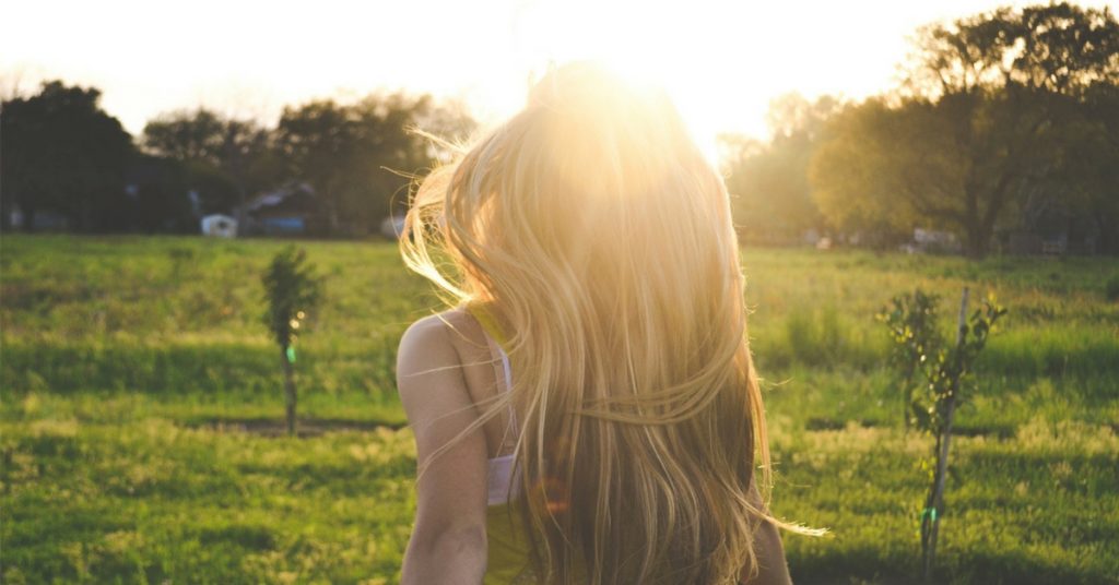 Walking in a field towards the sun